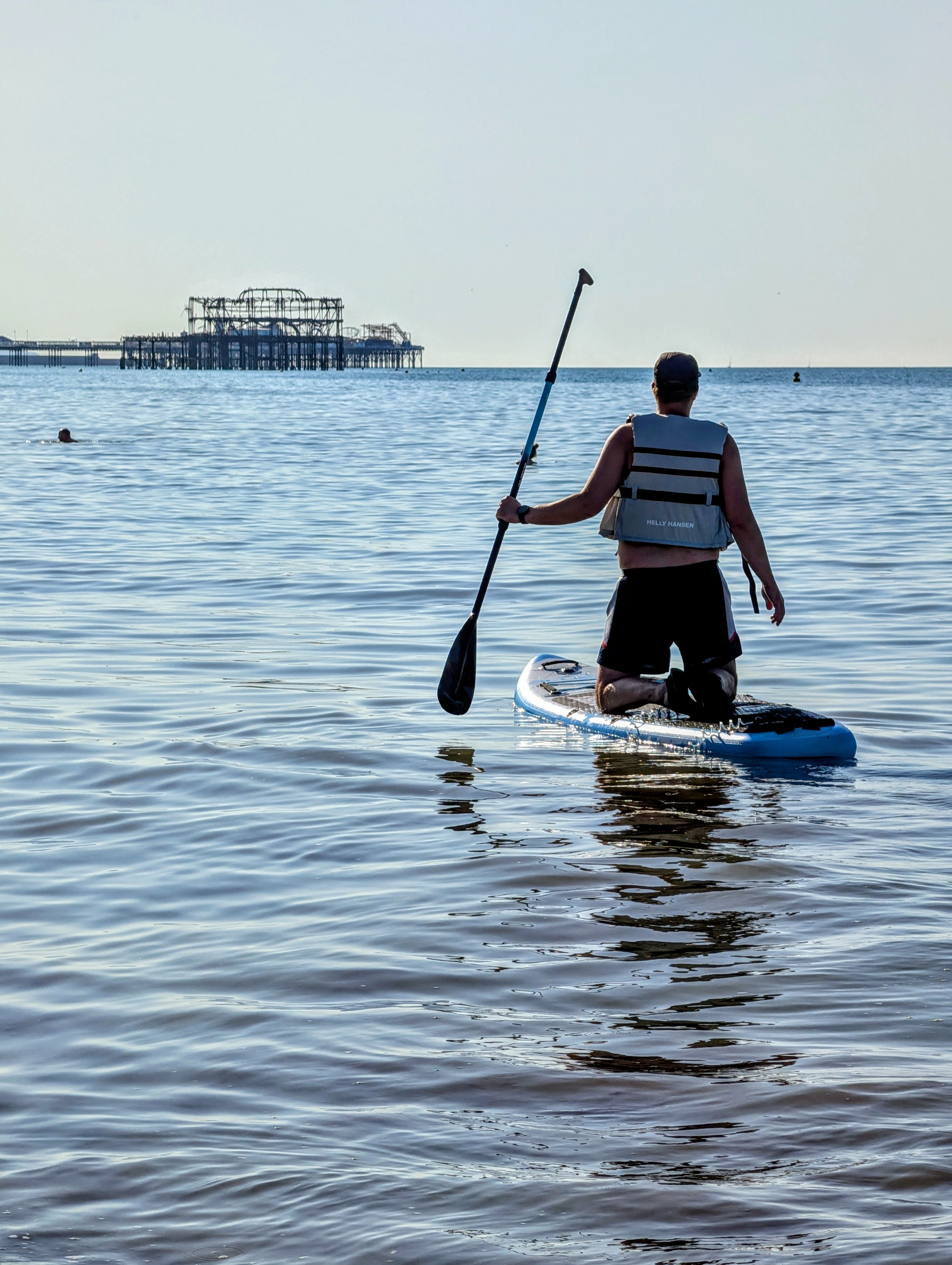 Paddleboarder heading toward West Pier ruins